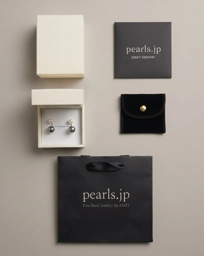 Pearls.jp packaging: a cream jewelry box with Tahitian pearl earrings, a black pouch, a pearl cleaner and a black gift bag